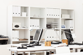 Ein weißes Büro mit Regalen und Computern